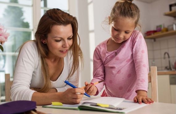 Photo of homeschooling child with mom as teacher