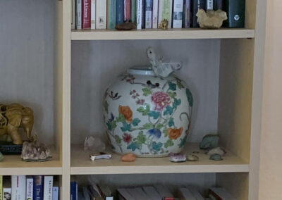 Photo of book shelf close-up: highlighting books, a vase, and some crystals (Lafayette).