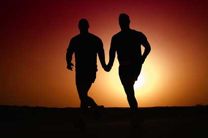 Photo of silhouette of gay couple at sunset