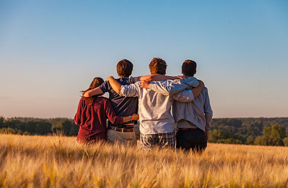 Photo of four teenagers in a line facing away