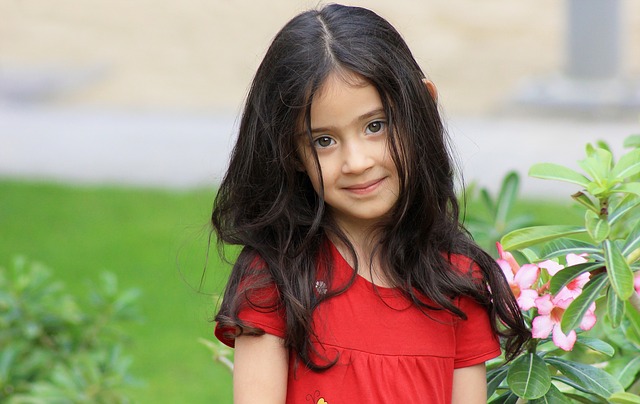 photo of young girl wearing a red dress and looking at the camera